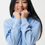 Jeune femme souriante en pull bleu clair