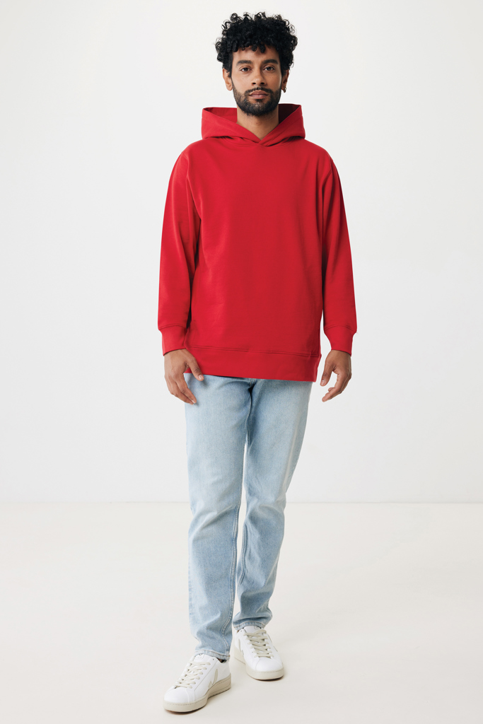 Homme portant sweat à capuche rouge et jean clair