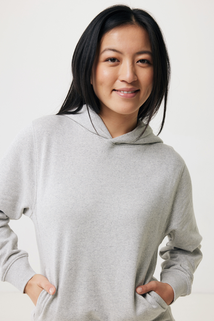 Femme souriante portant un sweat à capuche gris