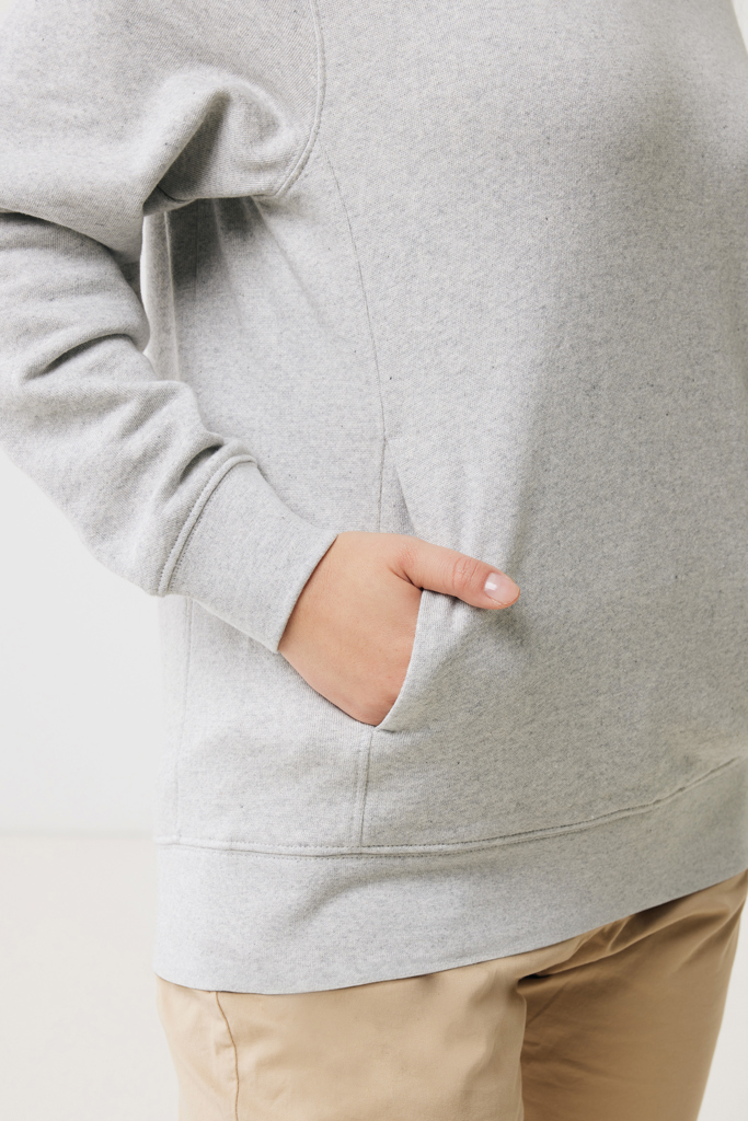Main dans la poche d’un sweat gris