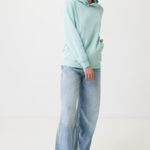 Personne souriante en sweat vert et jean large