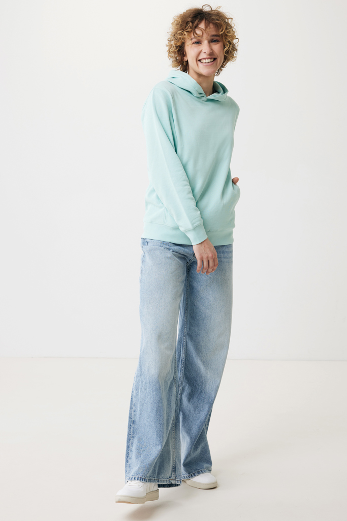 Personne souriante en sweat vert et jean large