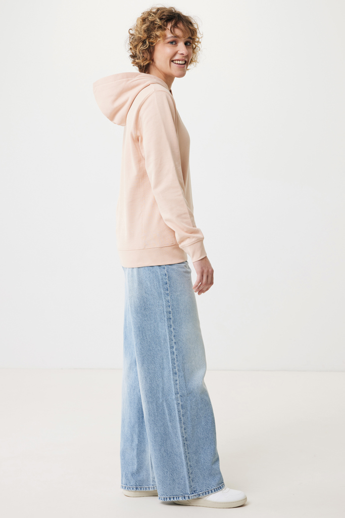 Femme souriante en hoodie rose et jean large