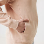 Personne portant un sweat beige, main dans la poche