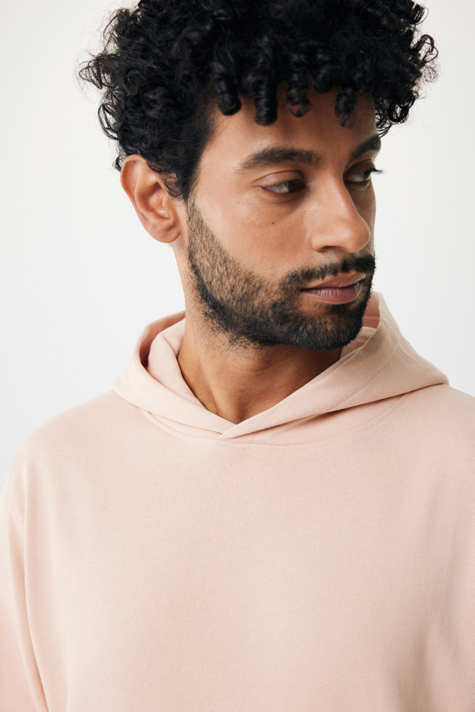 Homme barbu aux cheveux bouclés en hoodie rose