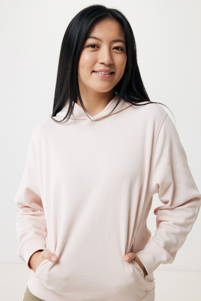Femme souriante portant un sweat à capuche rose
