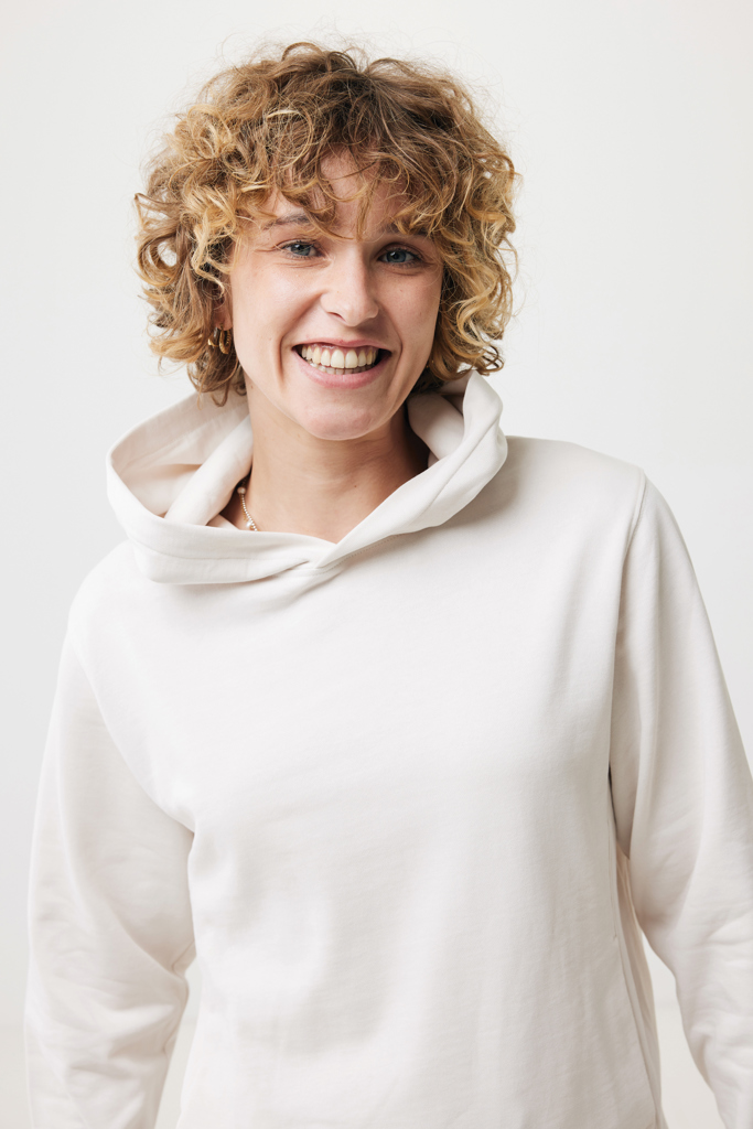 Personne souriante aux cheveux bouclés en hoodie clair