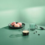Macarons roses et café sur table verte