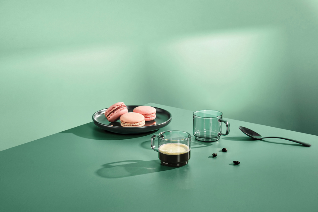 Macarons roses et café sur table verte