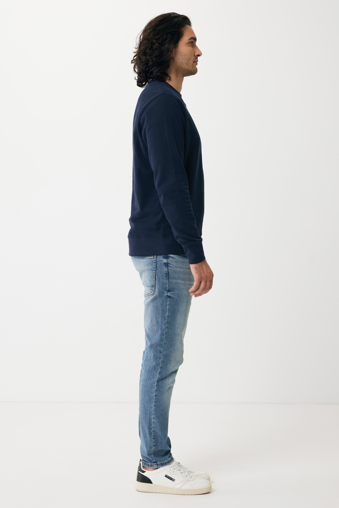 Homme de profil en pull bleu marine et jean clair