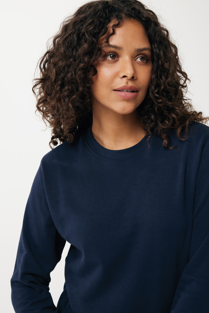 Femme aux cheveux bouclés portant un sweat bleu marine