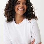 Femme souriante aux cheveux bouclés en pull blanc