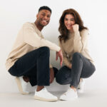 Couple souriant accroupi en tenue décontractée
