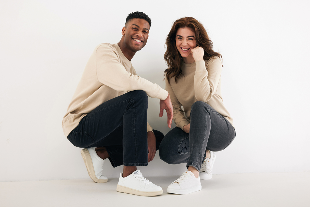 Couple souriant accroupi en tenue décontractée