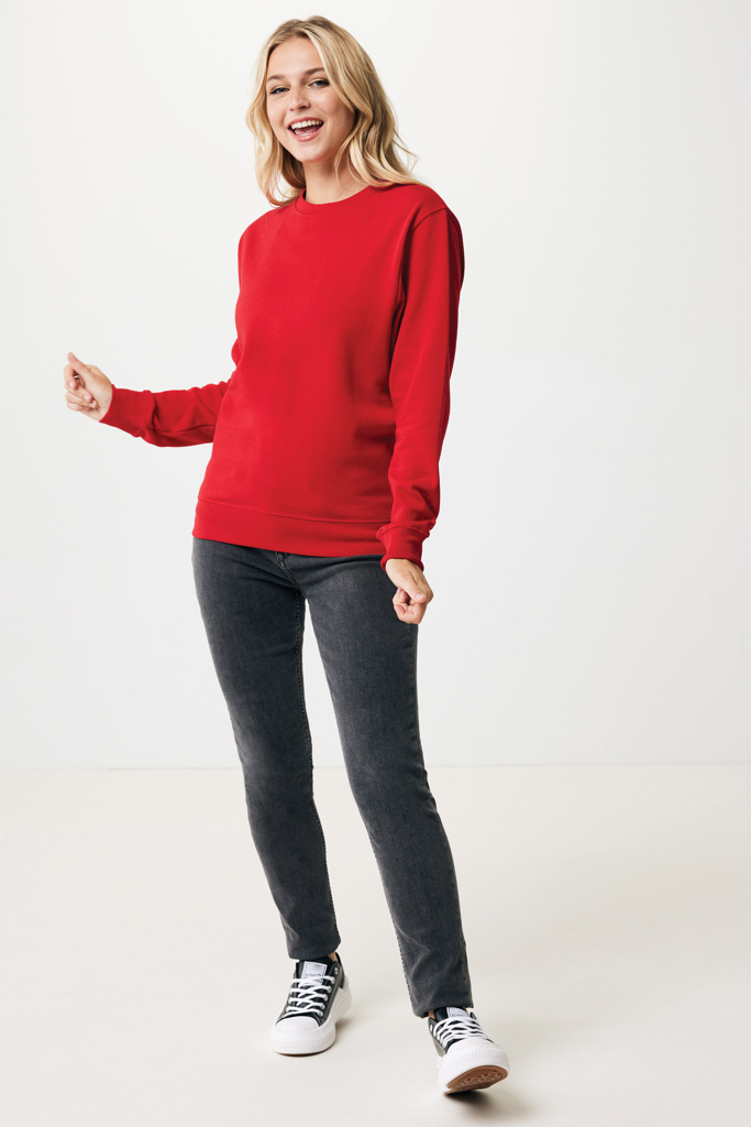 Femme souriante en sweat rouge et jeans