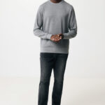 Homme souriant en sweat gris et jeans foncé