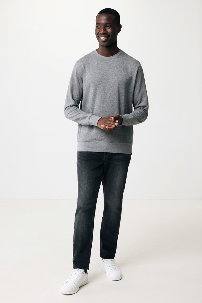 Homme souriant en sweat gris et jeans foncé