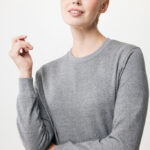 Femme aux cheveux courts blonds en pull gris
