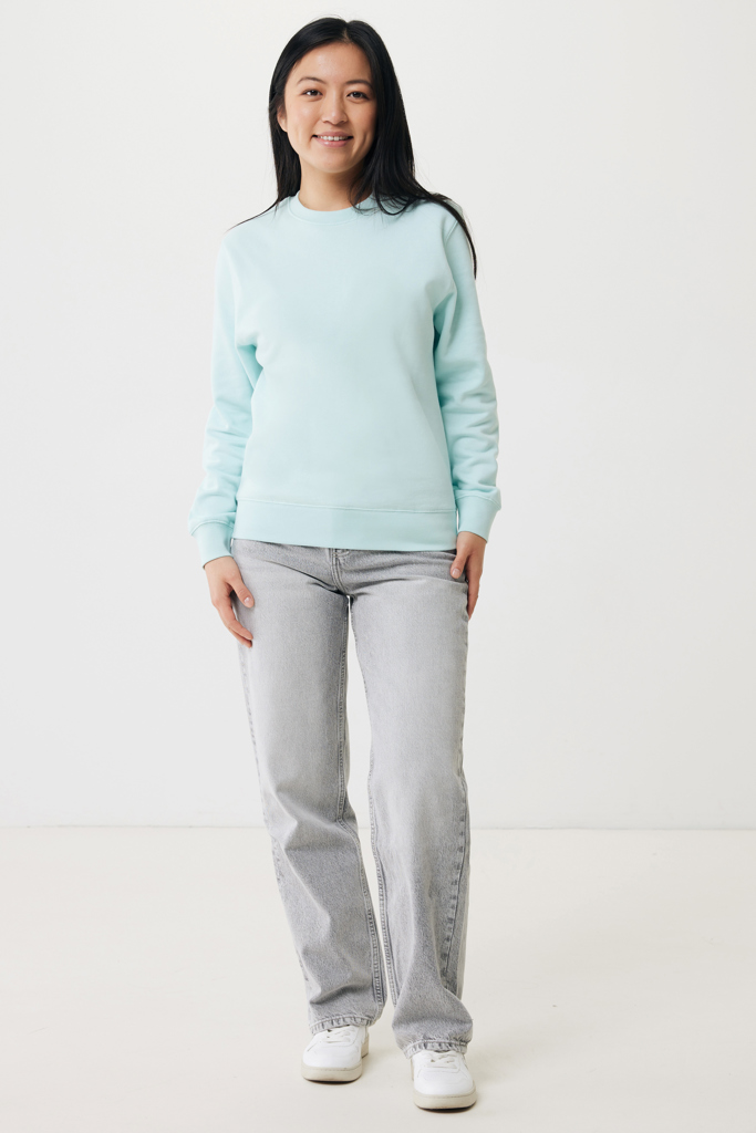Femme en sweat bleu clair et jean gris