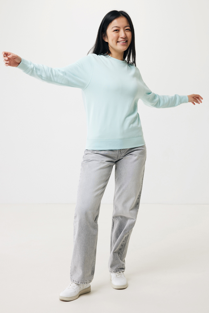 Femme souriante en sweat bleu, bras ouverts