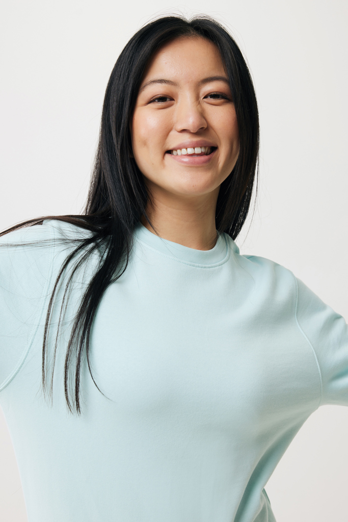 Portrait d’une femme souriante en haut bleu clair