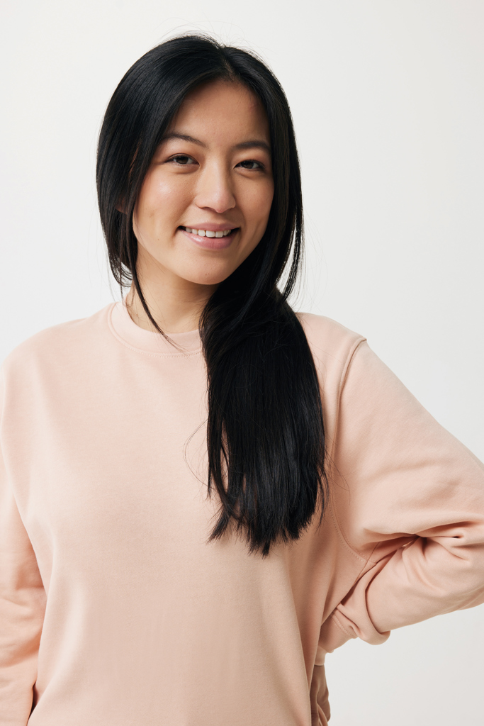 Femme souriante aux cheveux longs portant sweat rose