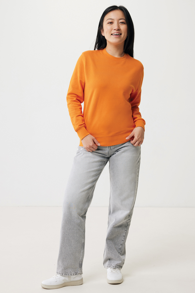 Femme en sweat orange et jean gris