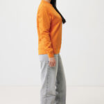 Femme de profil en sweat orange et jean