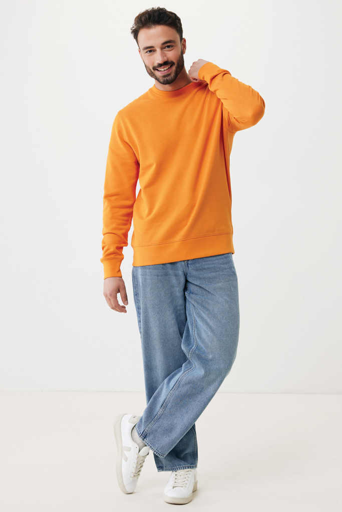 Homme souriant en sweat orange et jean