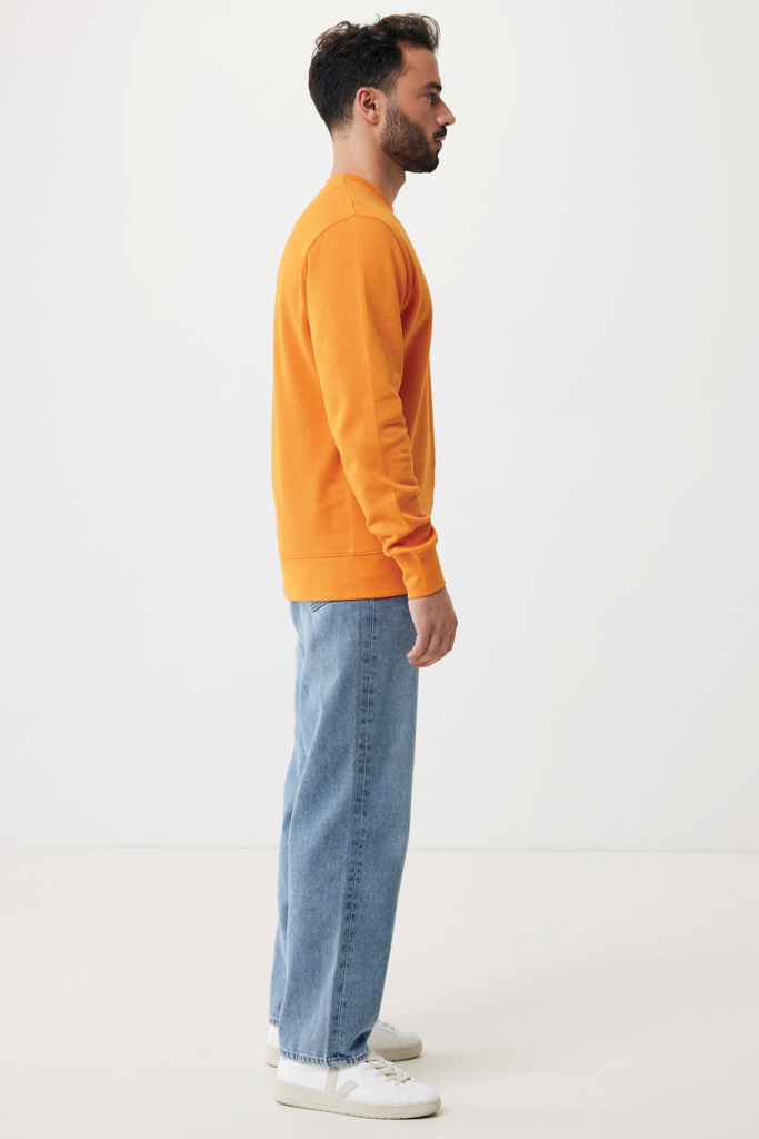 Homme de profil en sweat orange et jean