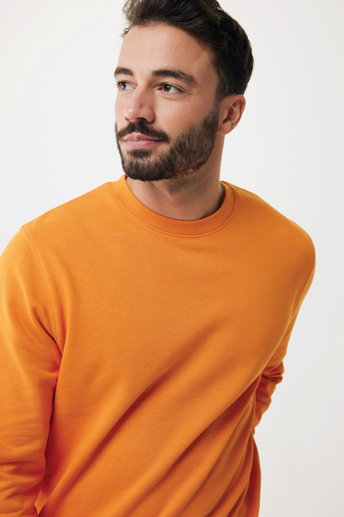 Homme barbu en sweat orange regardant au loin
