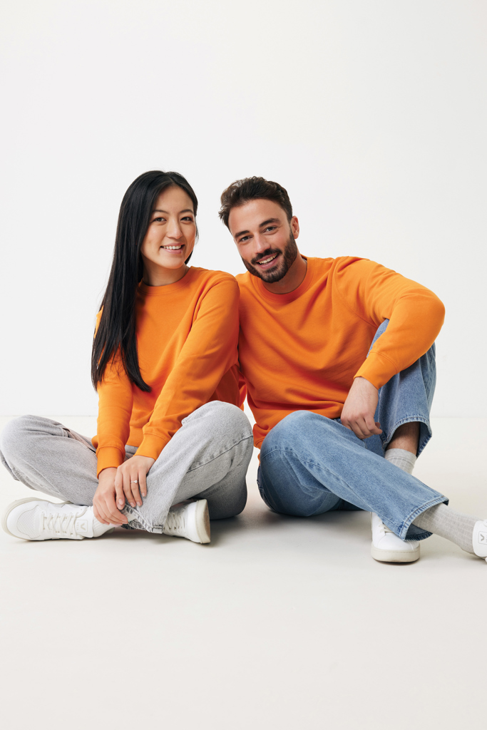 Deux personnes souriantes en pulls orange assises