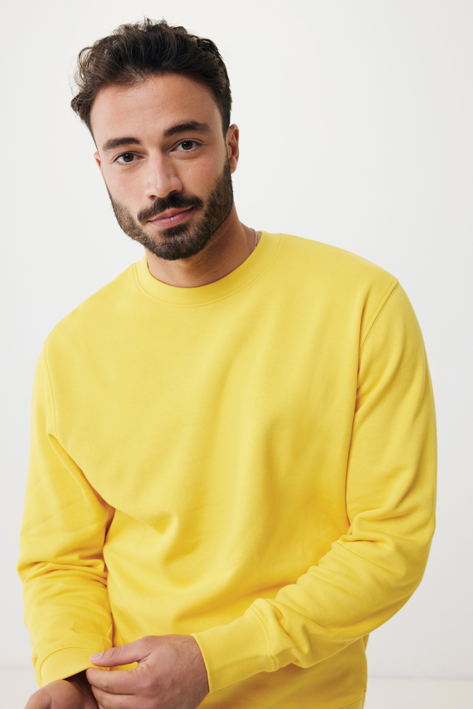 Homme barbu en sweat jaune sur fond neutre