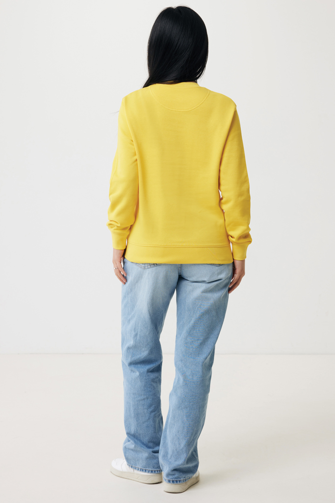 Femme de dos en sweat jaune et jean
