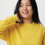 Femme souriante en sweat jaune sur fond neutre
