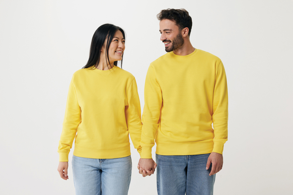Couple souriant en sweats jaunes se tenant la main