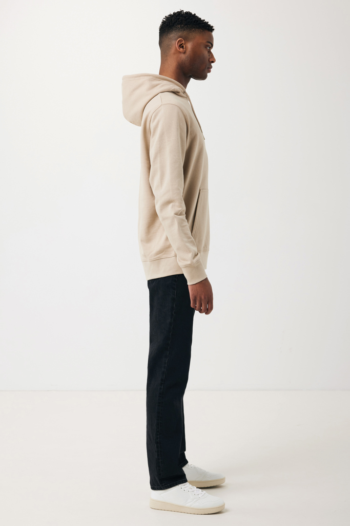 Homme de profil en hoodie beige et jean noir