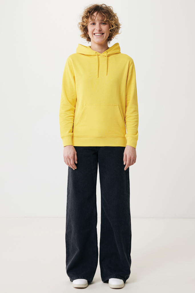 Femme en sweat à capuche jaune et pantalon large noir