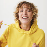 Jeune femme souriante en sweat jaune
