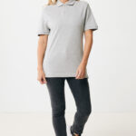 Femme souriante en polo gris et jean foncé