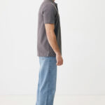 Homme de profil en polo gris et jean