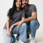 Couple souriant en polos gris et jeans