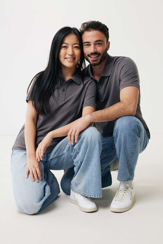Couple souriant en polos gris et jeans