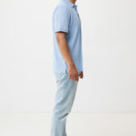 Homme debout de profil en polo bleu clair