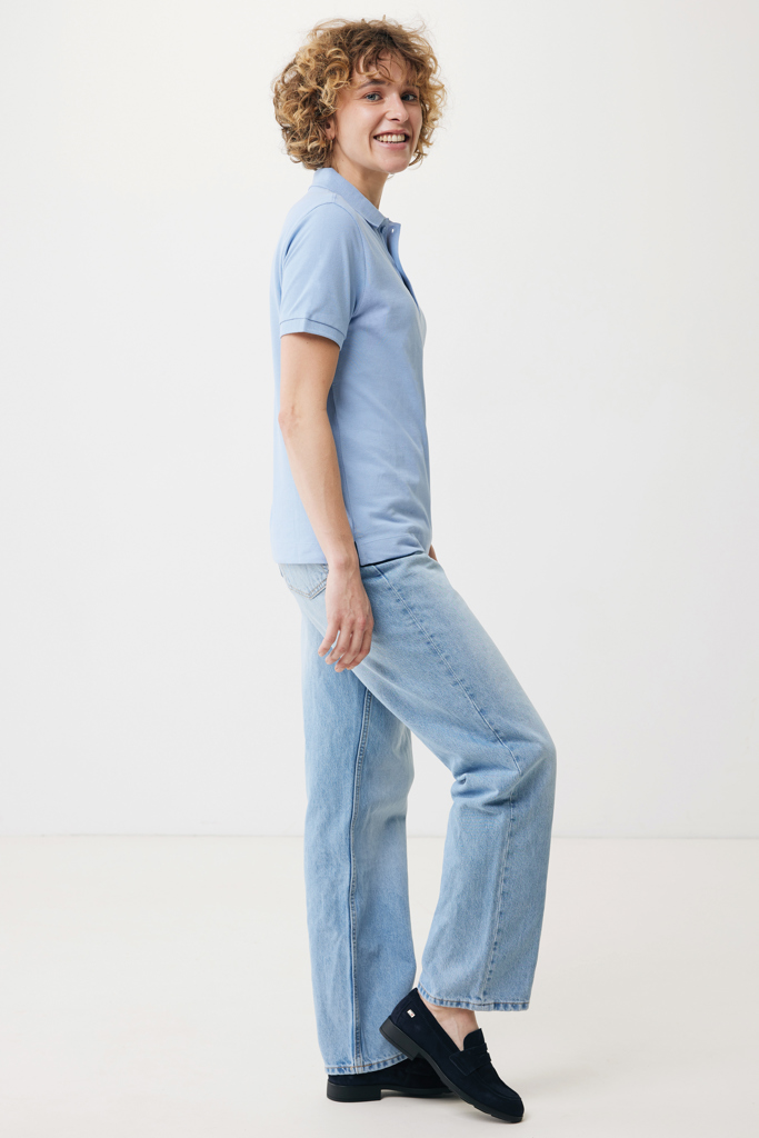 Femme souriante en polo bleu et jean clair