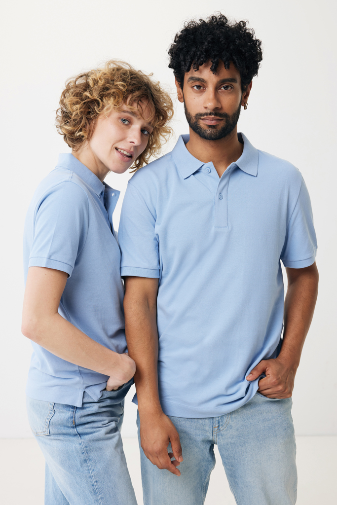 Deux personnes en polos bleus sur fond neutre