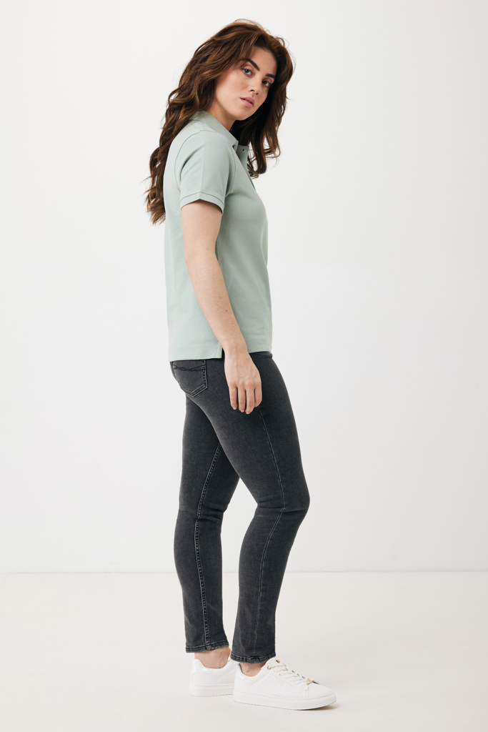 Femme en polo vert et jean foncé