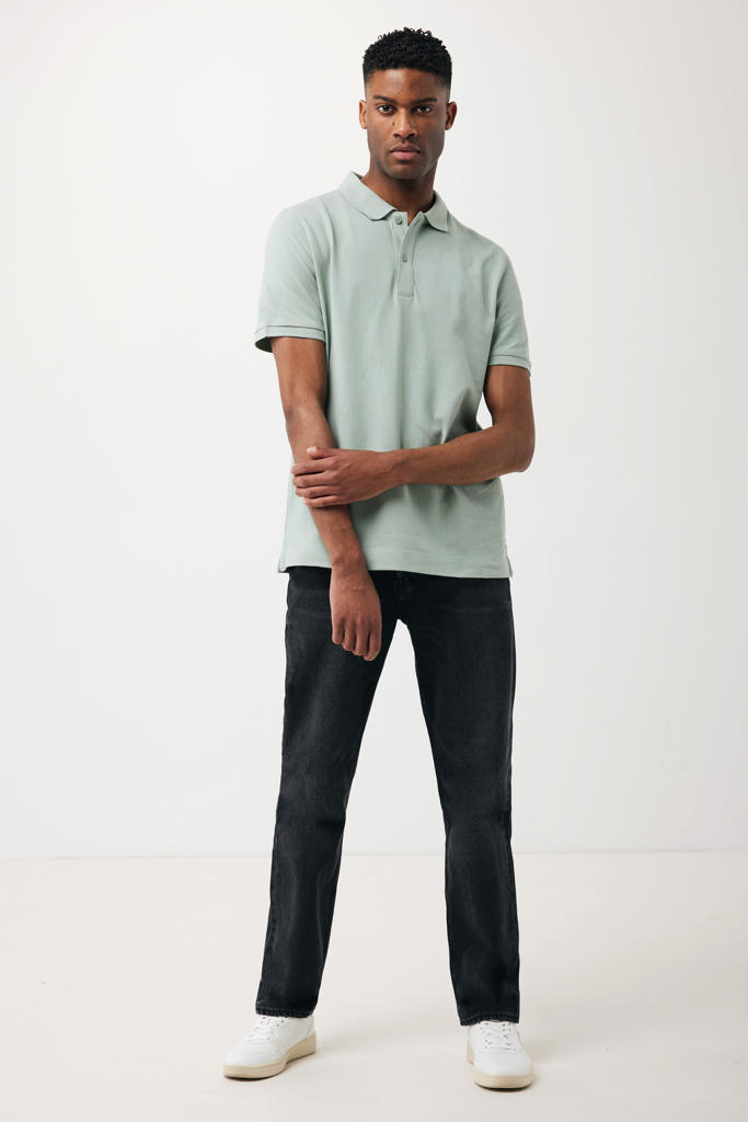 Homme portant polo vert et jean noir
