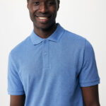 Homme souriant en polo bleu sur fond neutre