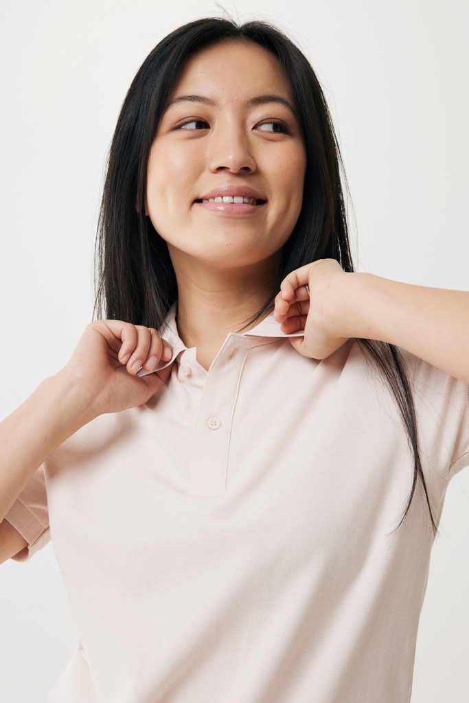 Femme souriante ajustant le col de son polo